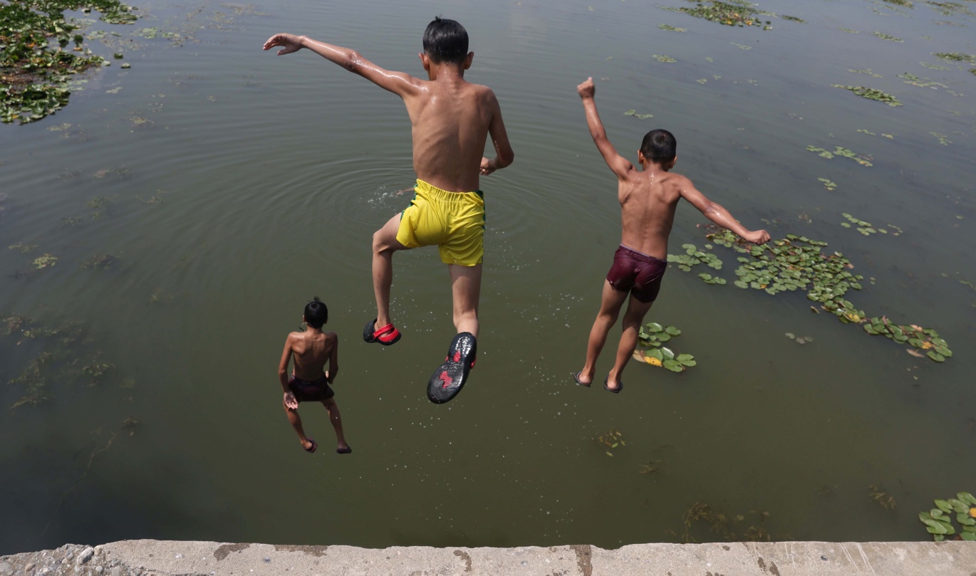Niños saltan al agua en las afueras de Srinagar, Cachemira. (Foto de Farooq Khan de la agencia EFE/EPA)