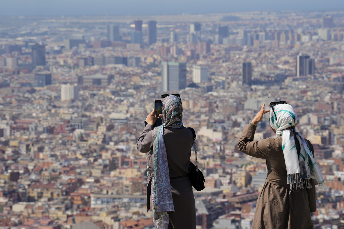 Turistas en el Turó de la Rovira de Barcelona este lunes cuando Cataluña vive el tercer día de la primera ola de calor de 2025. (Foto de Alejandro García de la agencia EFE)