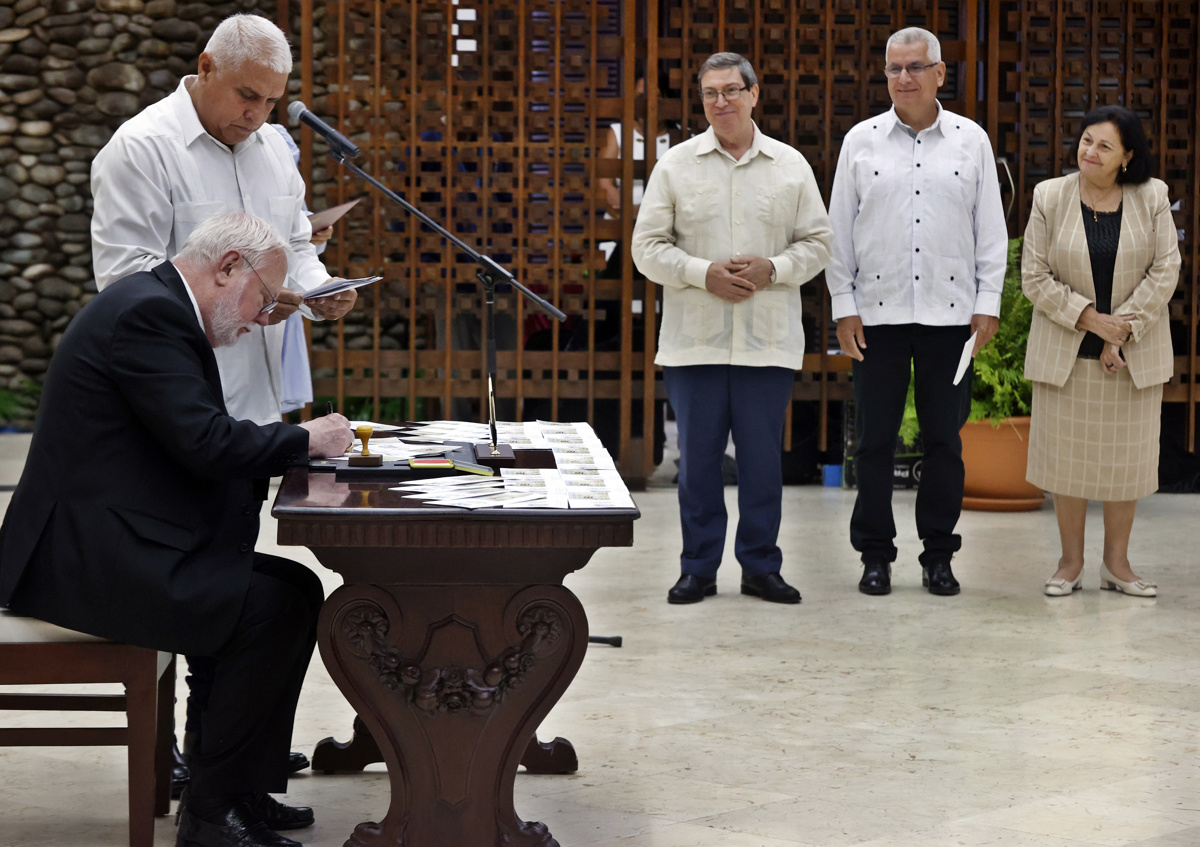 El secretario del Vaticano para las Relaciones con los Estados y los Organismos Internacionales, Paul Richard Gallagher (i), asiste a la cancelación de un sello postal que conmemora los 90 años de relaciones de Cuba con el Vaticano este 4 de junio de 2025, en La Habana (Cuba). (Foto de Ernesto Mastrascusa de la agencia EFE)