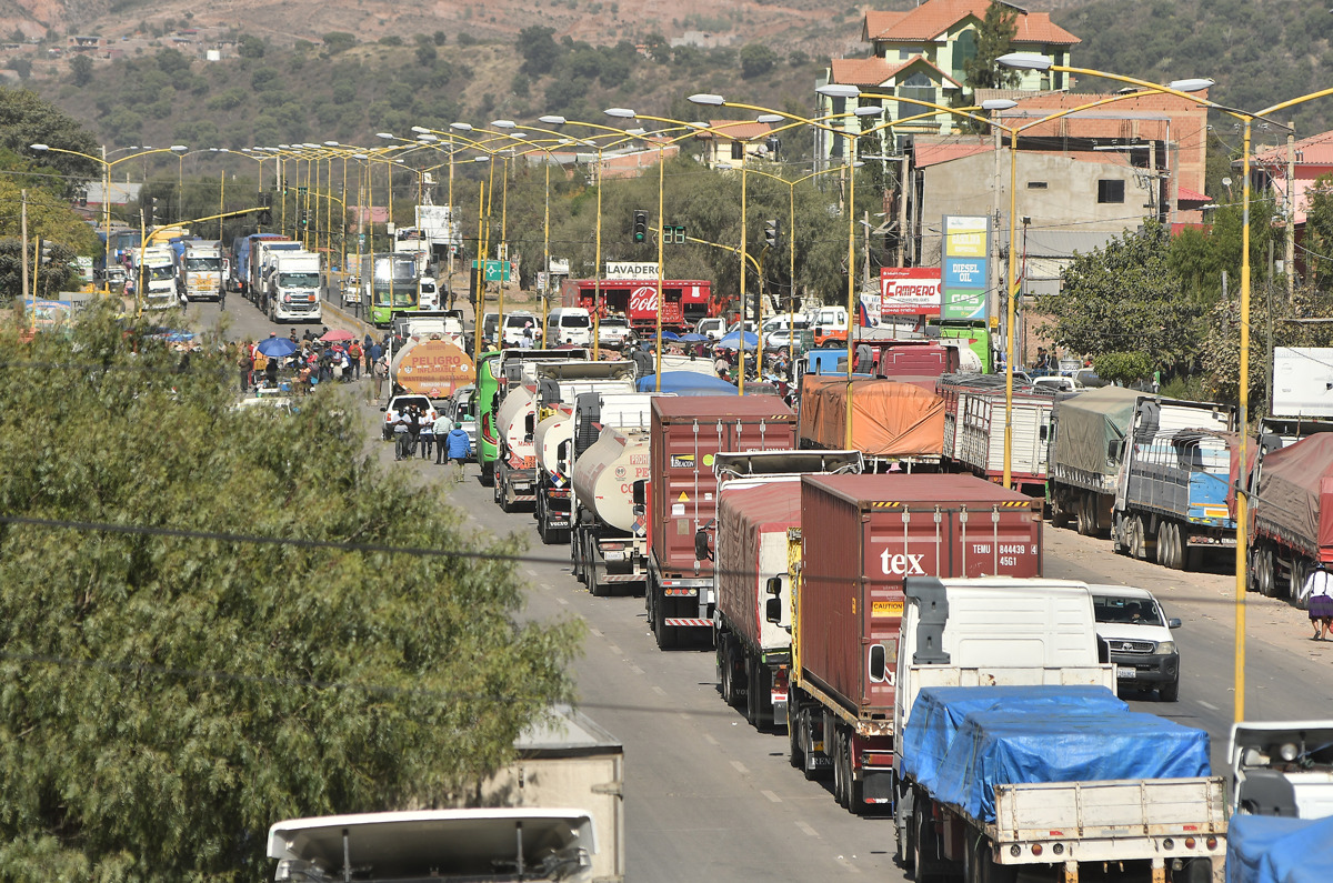 Camiones esperan en una carretera tras un bloqueo realizado por seguidores del exmandatario Evo Morales este lunes, en Sipe Sipe en la región de Cochabamba (Bolivia). (Foto de Jorge Abrego de la agencia EFE)