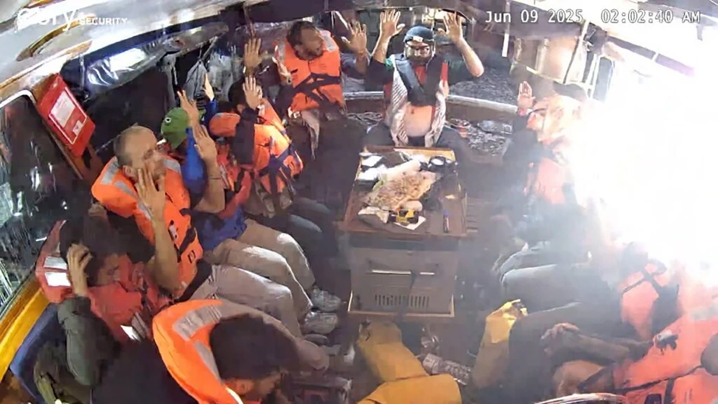 Fotografía facilitada por la Coalición de la Flotilla de la Libertad (FFC), de la tripulación del buque Madelein, con destino a Gaza, sentada en la embarcación, con chalecos salvavidas y las manos en alto, en el Mediterráneo, este lunes. (Foto de Coalición de la Flotilla de la Libertad EFE/EPA)