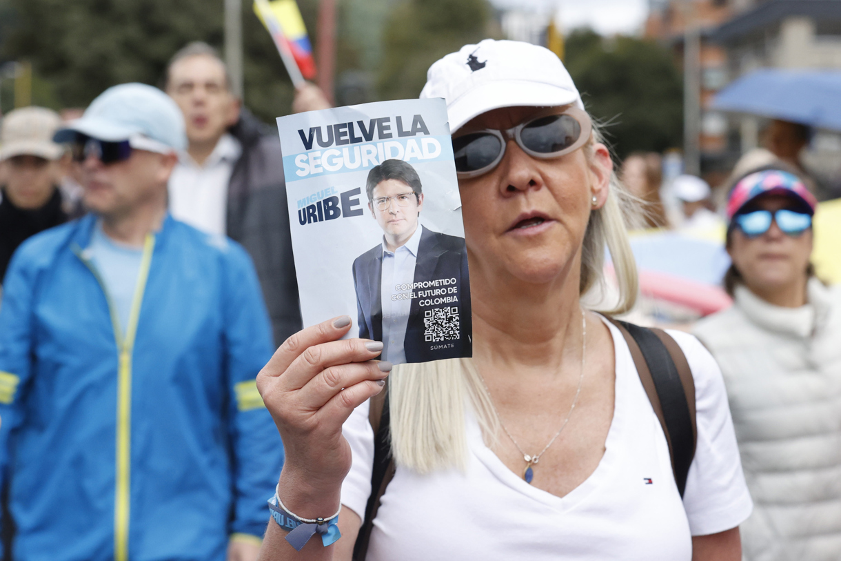 Una mujer sostiene un cartel durante una caminata por la paz y en apoyo al senador Miguel Uribe Turbay el 8 de junio de 2025, en Bogotá (Colombia). (Foto de Mauricio Dueñas Castañeda de la agencia EFE)
