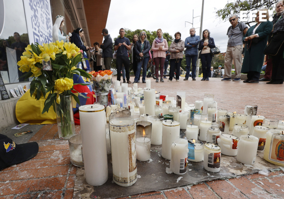 Personas observan un altar en honor al senador y precandidato presidencial colombiano Miguel Uribe Turbay, este miércoles en una de las entradas de la Fundación Santa Fe de Bogotá (Colombia). (Foto de Mauricio Dueñas Castañeda de la agencia EFE)