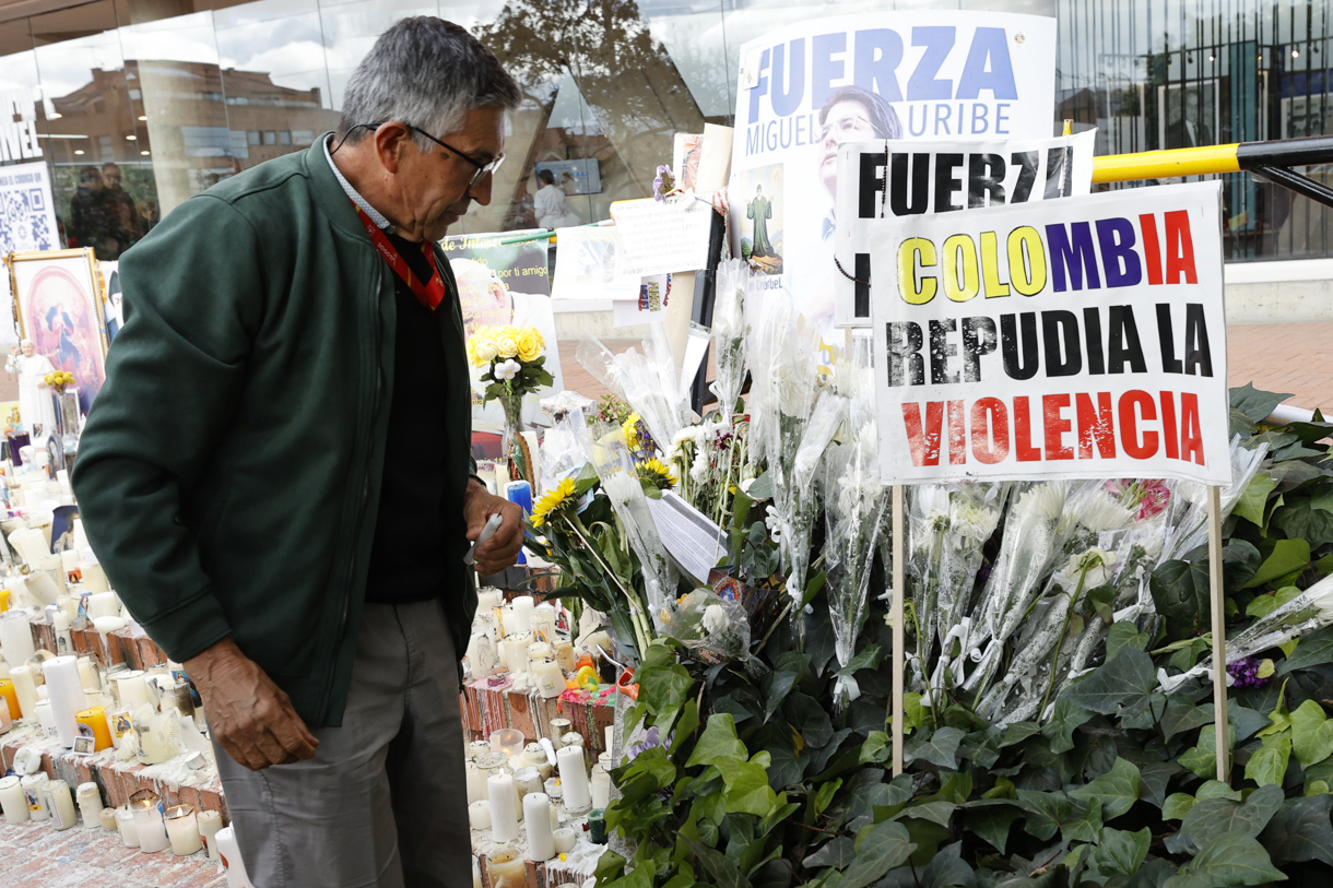 Un hombre observa un altar por la salud del senador Miguel Uribe Turbay frente a la Clínica Fundación Santa Fe de Bogotá (Colombia). (Foto de Mauricio Dueñas Castañeda de la agencia EFE)