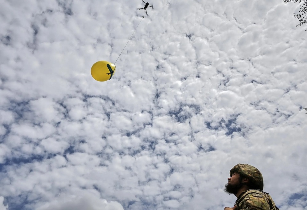 Un militar ucraniano levanta un dron acoplado a un globo para realizar prácticas de tiro durante un entrenamiento antidrones. (Foto de Sergey Kozlov de la agencia EFE)