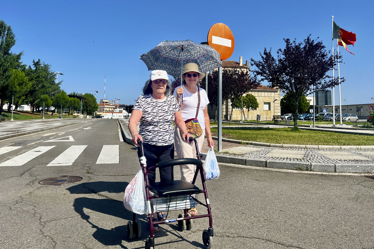 Dos mujeres pasean con el paraguas en la localidad portuguesa de Vilar Formoso (Portugal), para protegerse del sol. (Foto de Carlos García de la agencia EFE)