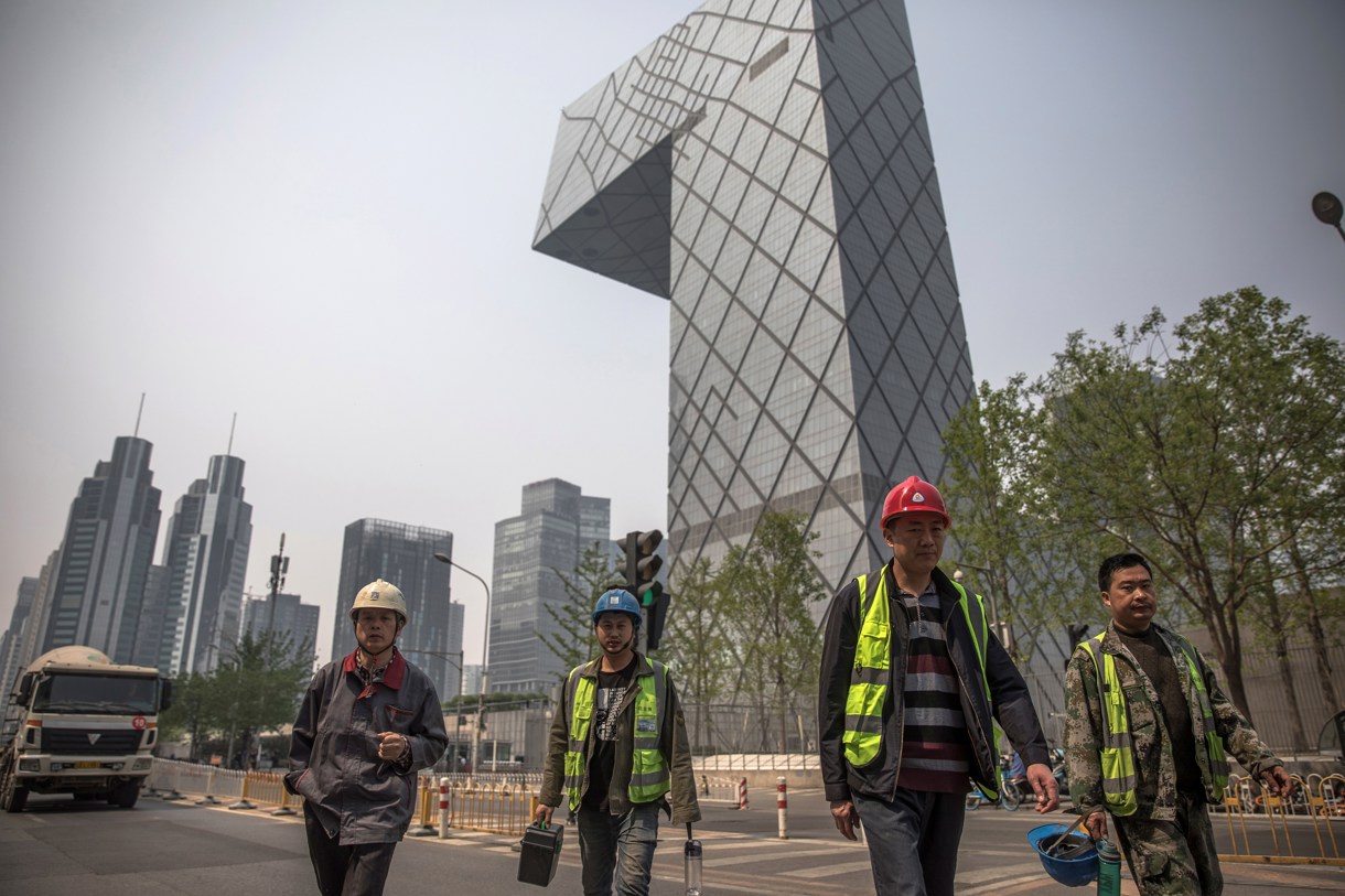 Trabajadores caminan por el distrito financiero de Pekín (China). (Foto de archivo de Roman Pilipey de la agencia EFE)