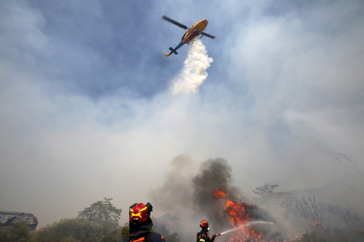Un helicóptero y bomberos intentan extinguir un incendio forestal en la montaña Ymittos, al este de Atenas, Grecia, el 28 de julio de 2025. (Foto de Alexandros Vlachos de la agencia EFE)