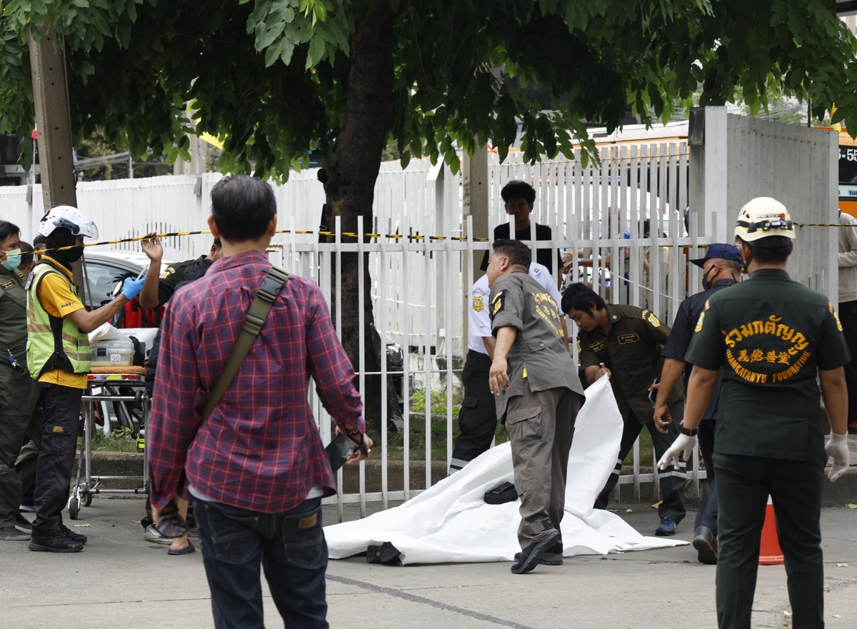 Equipos de emergencia tapan una víctima mortal del tiroteo registrado en Bangkok. (Foto de Narong Sangnak de la agencia EFE/EPA)