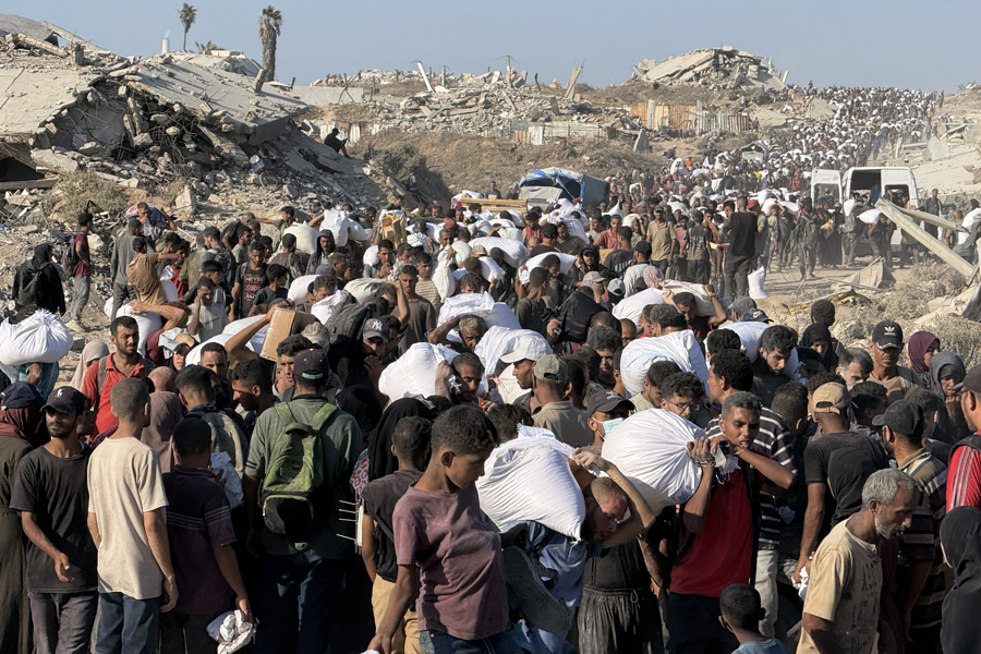 Miles de personas acuden a una zona militarizada cerca del cruce de Zikim, en el norte de la Franja de Gaza, para hacerse con harina del Programa Mundial de Alimentos. (Foto de EFE)