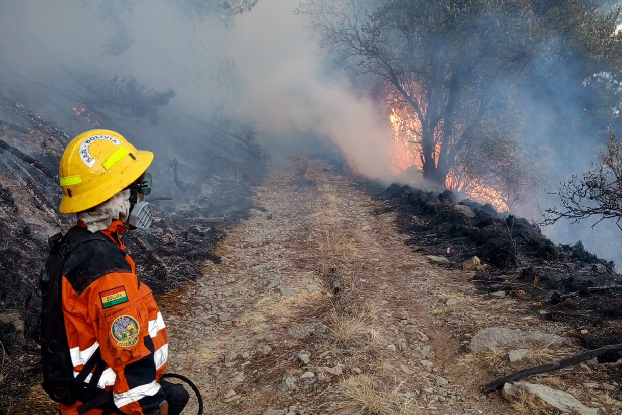 Fotografía cedida por el Grupo Voluntario de Salvamento de Cochabamba (SAR Bolivia) donde se muestra a un bombero observando un incendio forestal en el parque nacional Tunari este miércoles, en Cochabamba (Bolivia). (Foto de EFE/ Grupo Voluntario de Salvamento de Cochabamba)