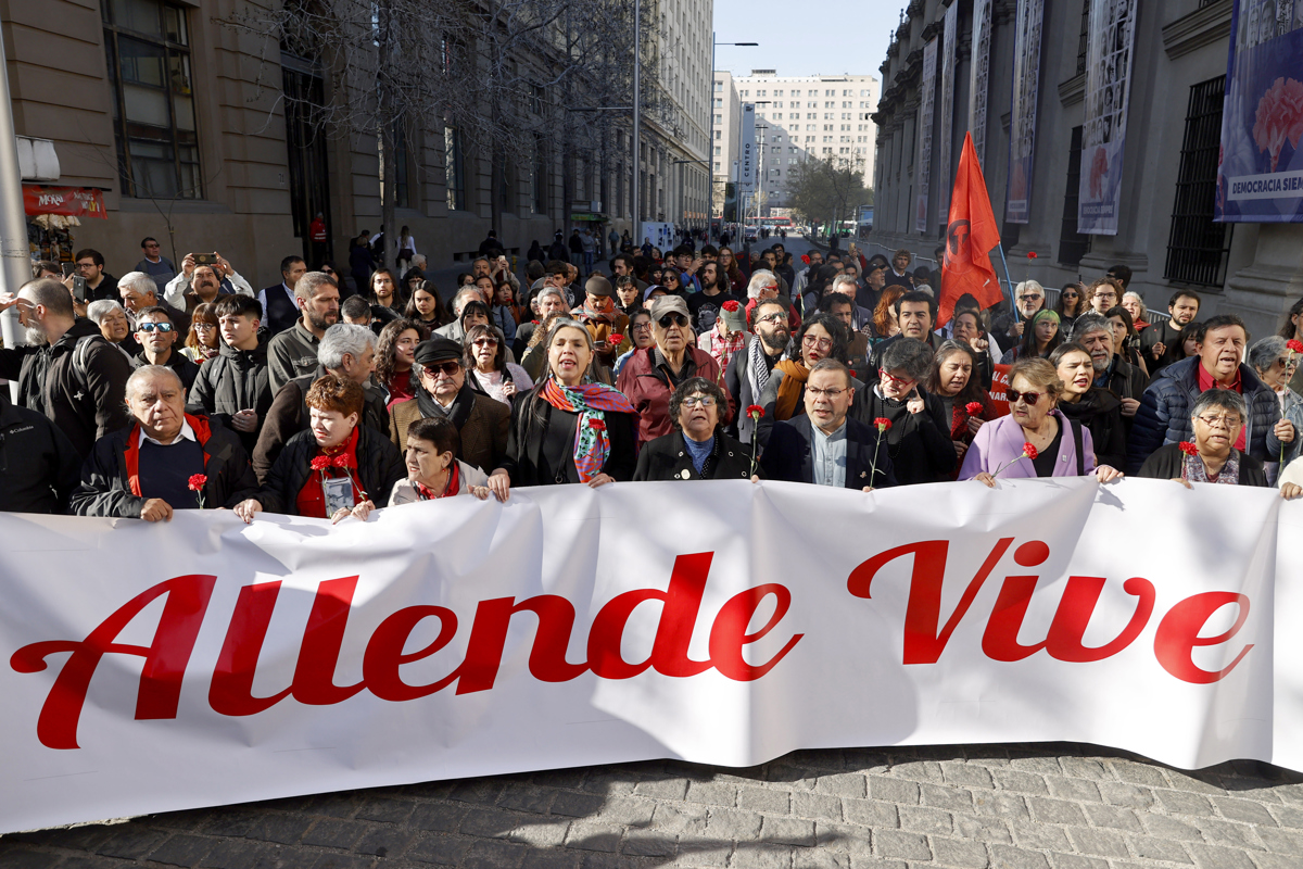 Personas sostienen un cartel durante la conmemoración de los 52 años del golpe de Estado este 11 de septiembre de 2025, frente al Palacio de La Moneda, en Santiago (Chile). (Foto de Elvis González de la agencia EFE)