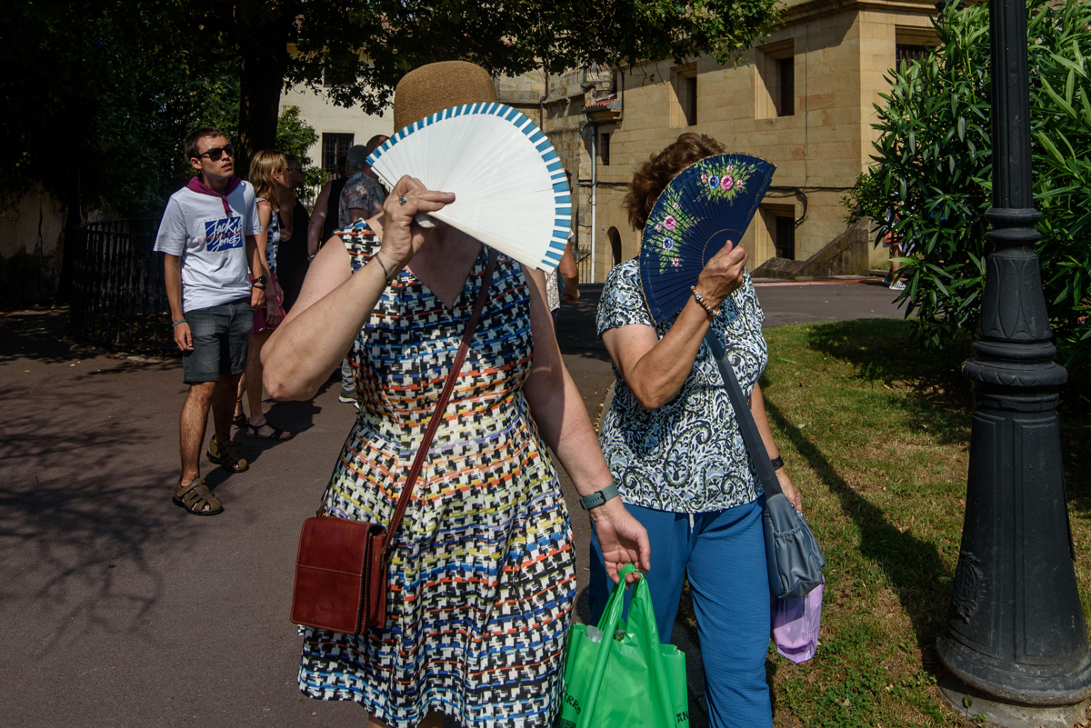Dos mujeres se protegen del sol con sus abanicos, el pasado mes de agosto en Bilbao. (Foto de archivo de Javier Zorrilla de la agencia EFE)