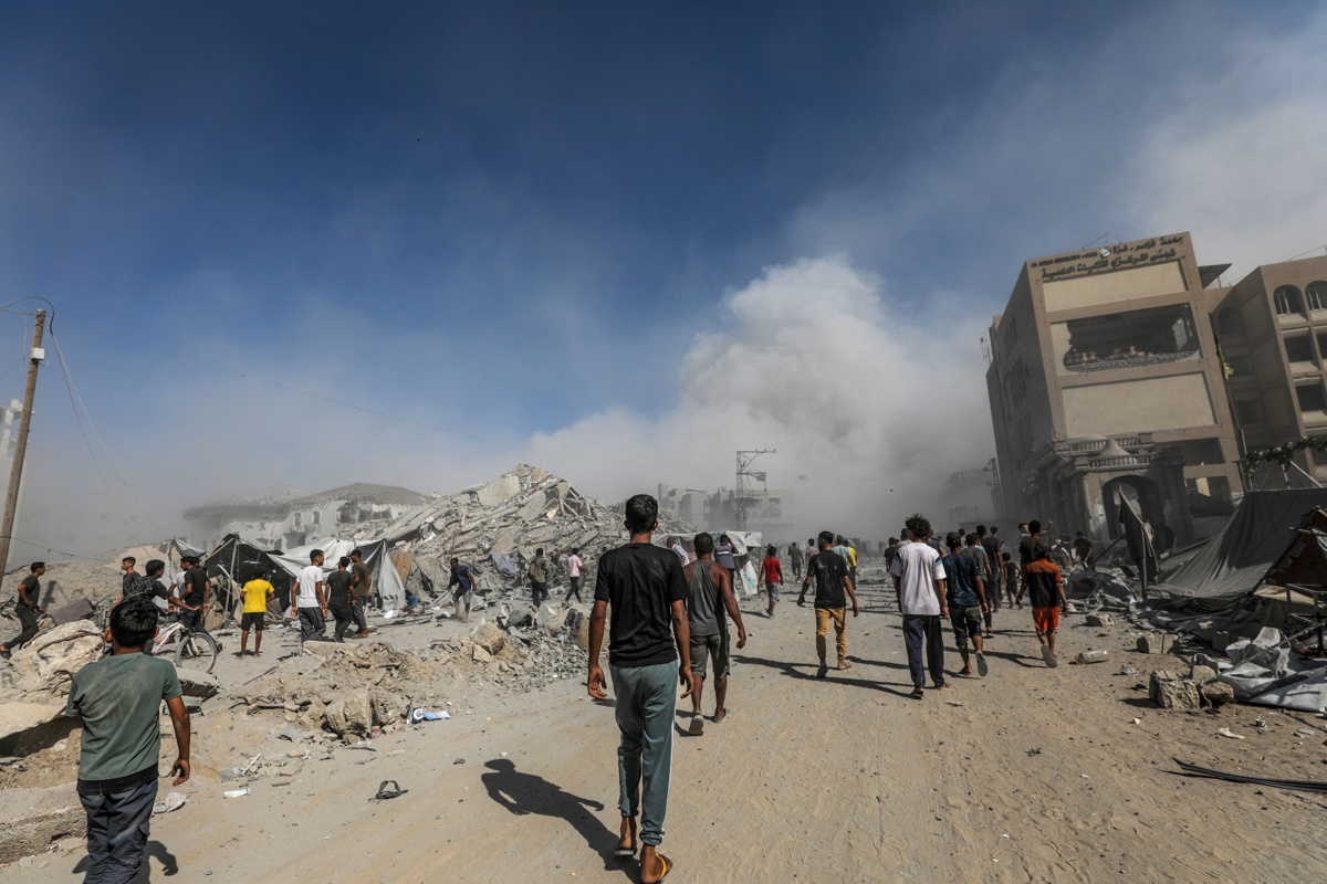 Los palestinos pasan junto a los escombros mientras el humo se eleva del edificio residencial al-Roya tras un ataque aéreo israelí en el oeste de la ciudad de Gaza, Franja de Gaza, 8 de septiembre de 2025. (Foto de Mohammed Saber de la agencia EFE/EPA)