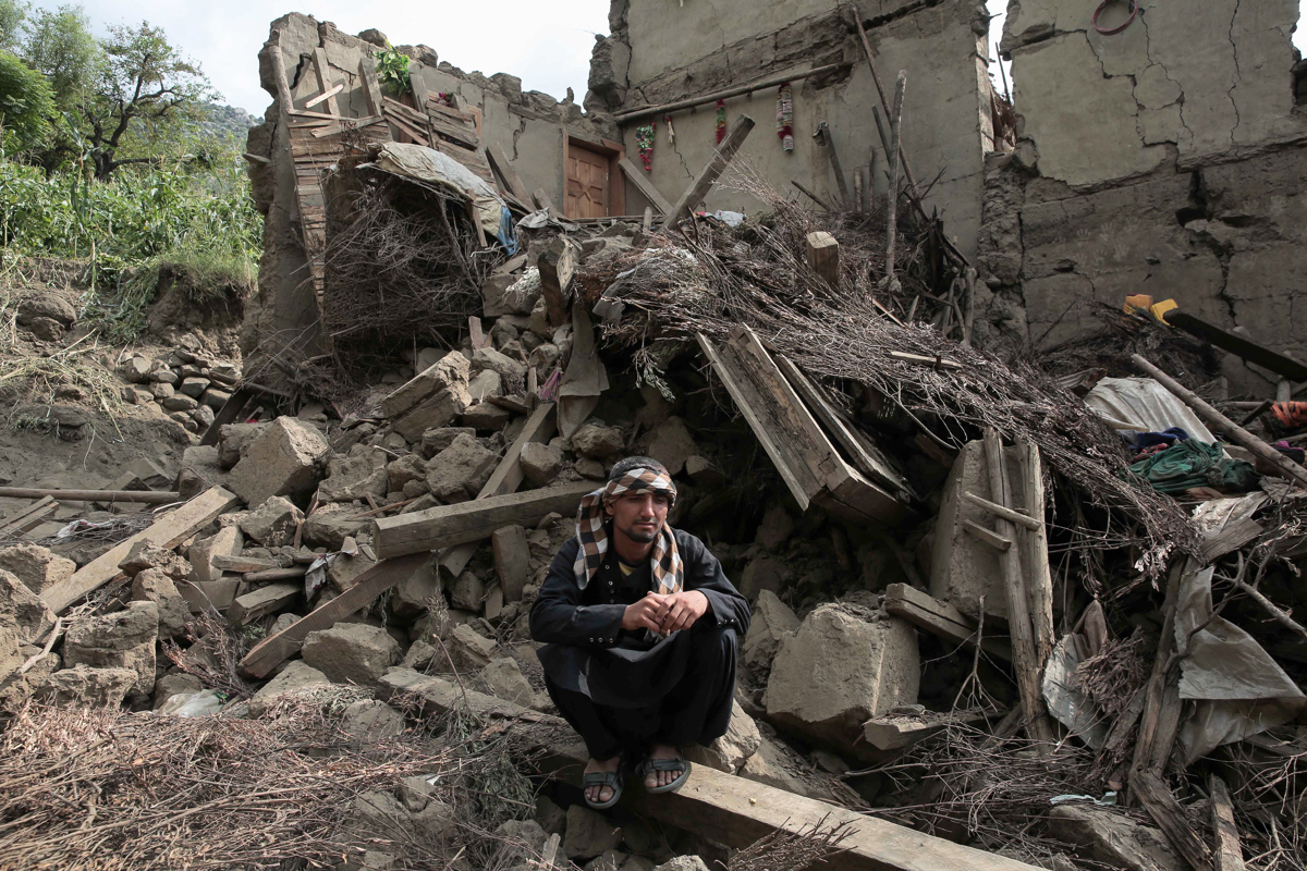 Una víctima del terremoto sentada junto a los escombros de una casa dañada este miércoles en Kunar (Afganistán). (Foto de Samiullah Popal de la agencia EFE/EPA)