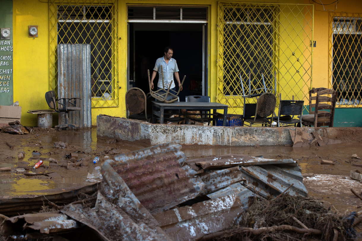 Una persona saca enseres de una vivienda en Santa Cruz, Jamaica, tras el paso del huracán Melissa. (Foto de Orlando Barría de la agencia EFE)
