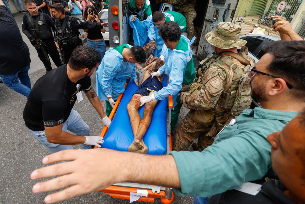 Integrantes de equipos médicos trasladan a una persona a un hospital durante un operativo policial este martes, en Río de Janeiro (Brasil). (Foto de Antonio Lacerda de la agencia EFE)
