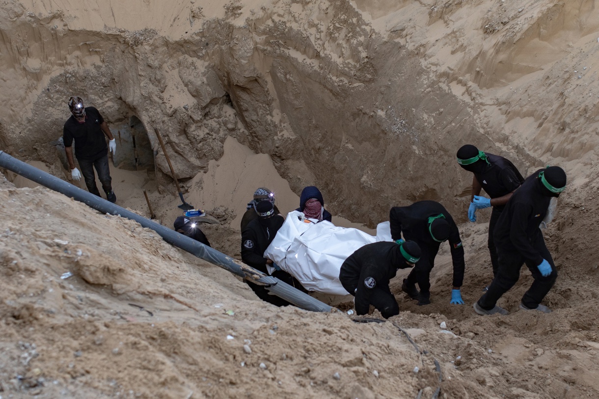 Militantes de Hamas llevan una bolsa blanca que contiene un cuerpo después de recuperarlo de un túnel en Khan Yunis, sur de Gaza, el 28 de octubre de 2025. (Foto de Haitham Imad de la agencia EFE/EPA)