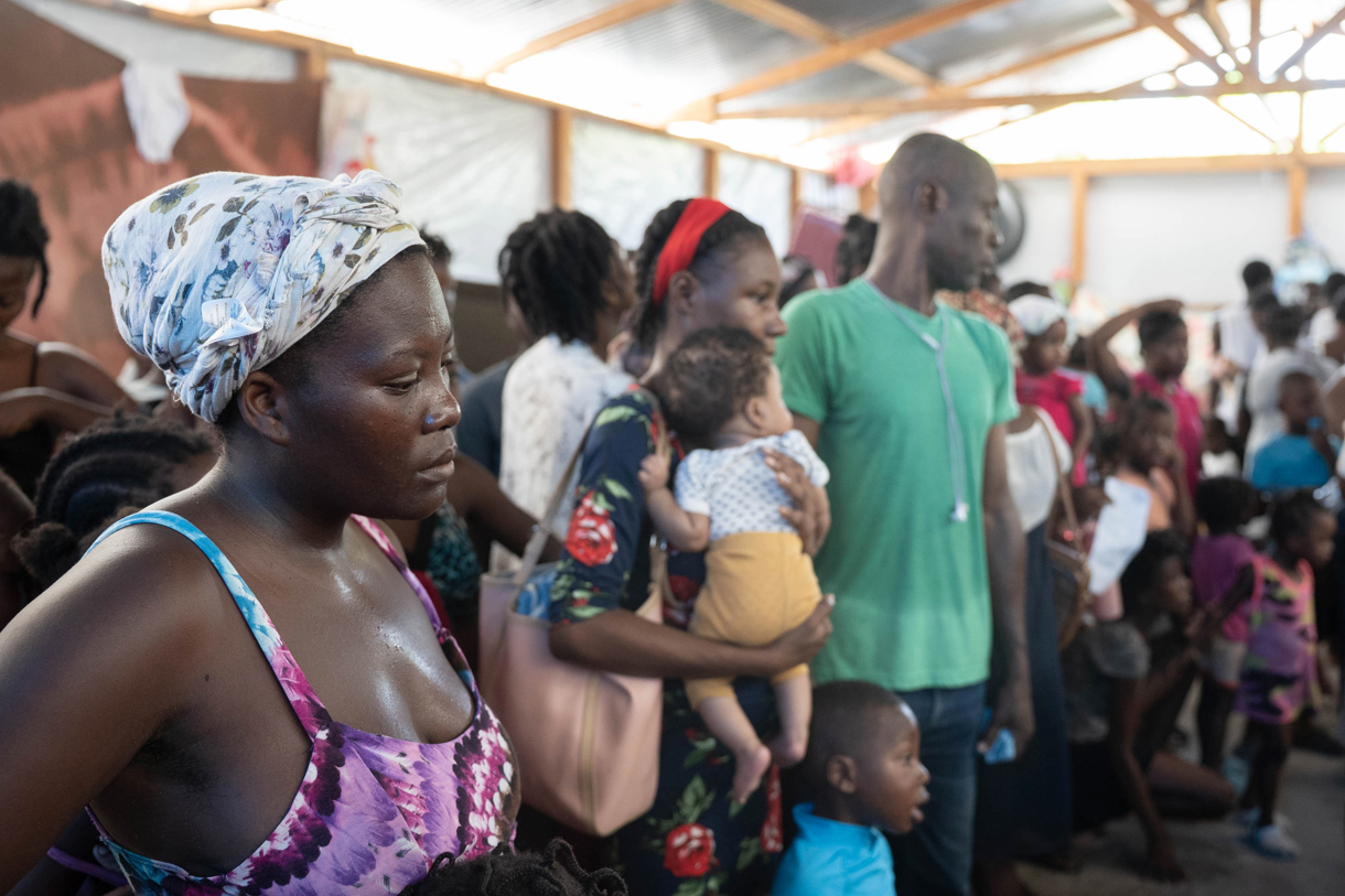 Fotografía del 1 de octubre de 2025, cedida por el Programa Mundial de Alimentos que muestra a personas desplazadas recibiendo comida en un refugio en Puerto Príncipe (Haití). ( EFE/ María Gallar /Programa Mundial de Alimentos)