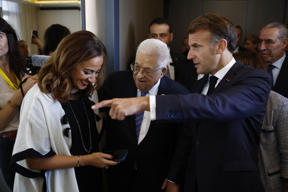 El presidente francés, Emmanuel Macron (derecha) y el de la Autoridad Nacional Palestina, Mahmud Abás (centro) hablan con la parlamentaria francesa Amelia Lakrafi tras su llegada a la ciudad-balneario egipcia de Sharm el-Sheij para la llamada “Cumbre de Paz” sobre Gaza. (Foto de Yoan Valat de la agencia EFE/EPA)
