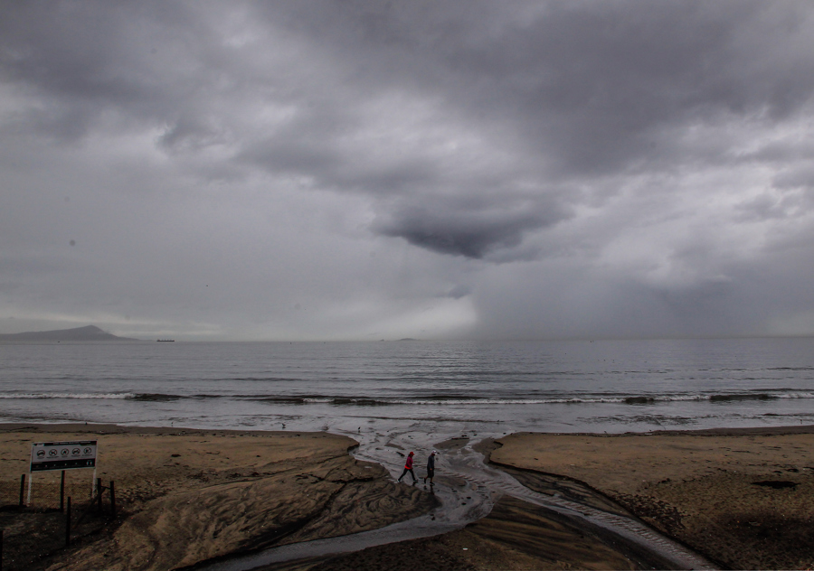 Fotografía de archivo de EFE de una pareja caminando por la playa, en Ensenada, Baja California.