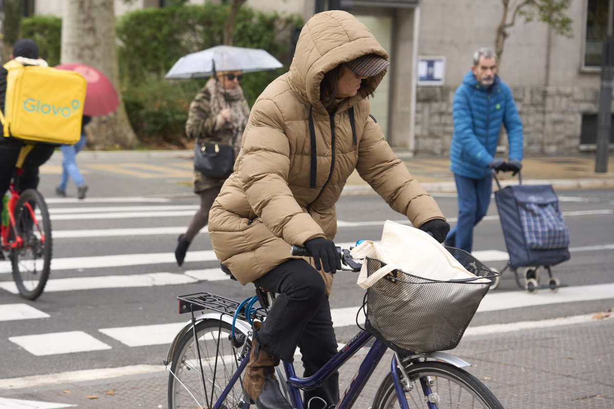Una mujer circula en bicicleta y muy abrigada este miércoles en Vitoria. (Foto de L. Rico de la agencia EFE)