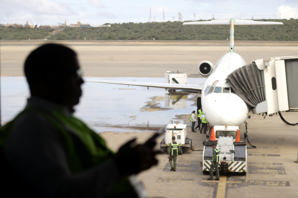 Perfil a contraluz de un pasajero a la espera de abordar un avión, este miércoles, 26 de noviembre, en el aeropuerto internacional Simón Bolívar, que sirve a Caracas, en Maiquetía (Venezuela). (Foto de Ronald Peña de la agencia EFE)
