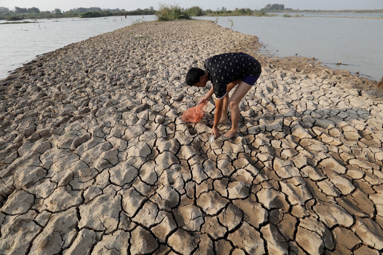 Un camboyano cazando un pescado, a las afueras de Nom Pen, Camboya, en medio de una sequía debido a los efectos del fenómeno climático “El Niño”. (Foto de Mak Remissa de la agencia EFE)
