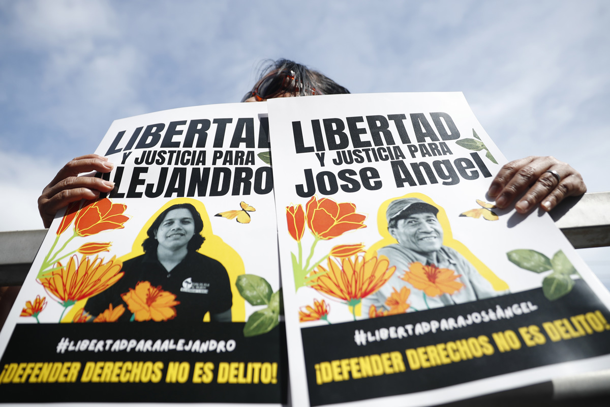 Personas sostienen carteles en apoyo a los activistas y líderes comunitarios Alejandro Henríquez y José Ángel Pérez en El Salvador. (Foto de Rodrigo Sura de la agencia EFE)