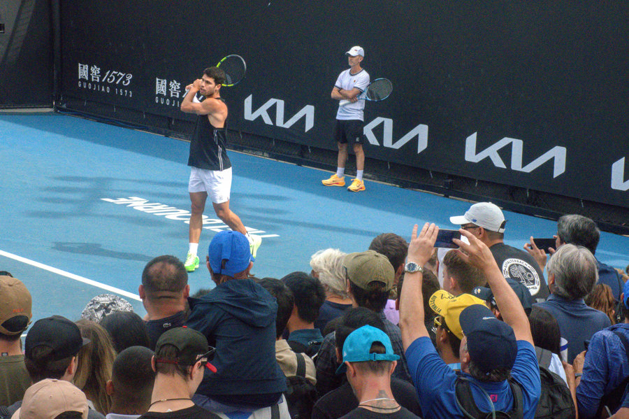 Decenas de aficionados asisten a un entrenamiento del tenista español Carlos Alcaraz en el Parque de Melbourne, sede del Abierto de Australia. (Foto de EFE)