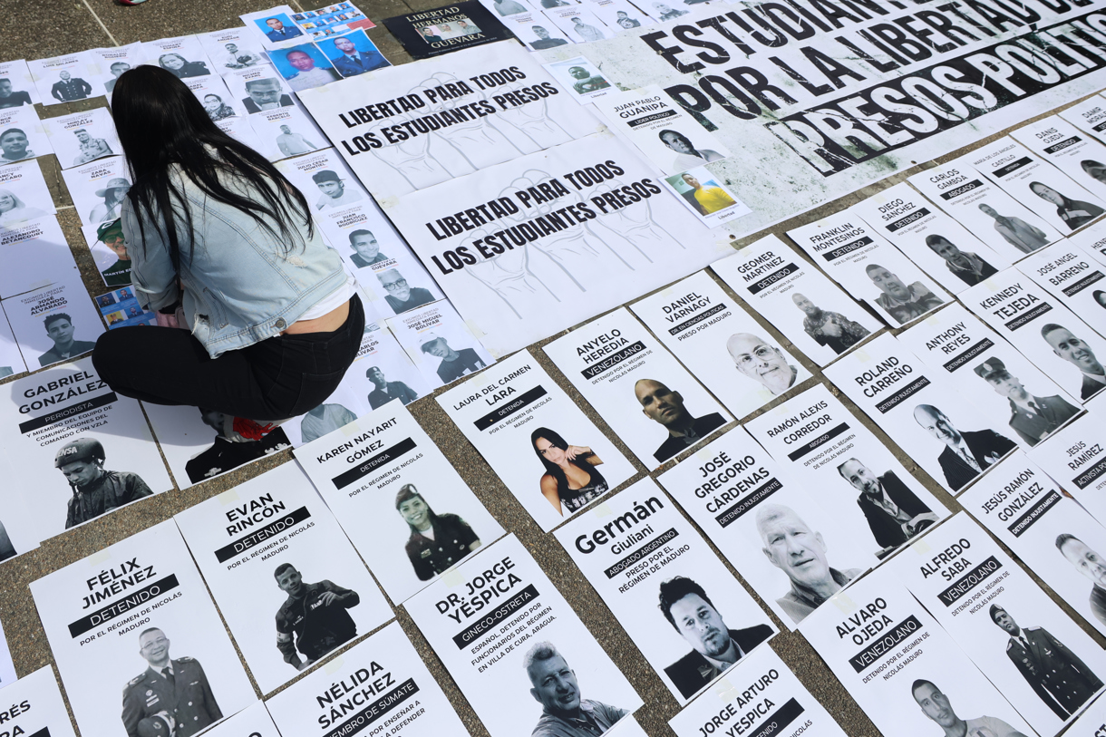 Una persona organiza carteles con imágenes de presos políticos este martes, en la Plaza del Rectorado UCV, en Caracas (Venezuela). (Foto de Miguel Gutiérrez de la agencia EFE)