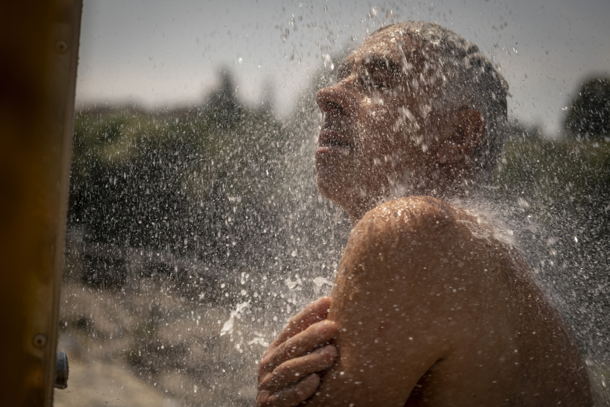 Un hombre se refresca en una ducha en las termas de A Chavasqueira, en Ourense, España. Foto de archivo de Brais Lorenzo de la agencia EFE)