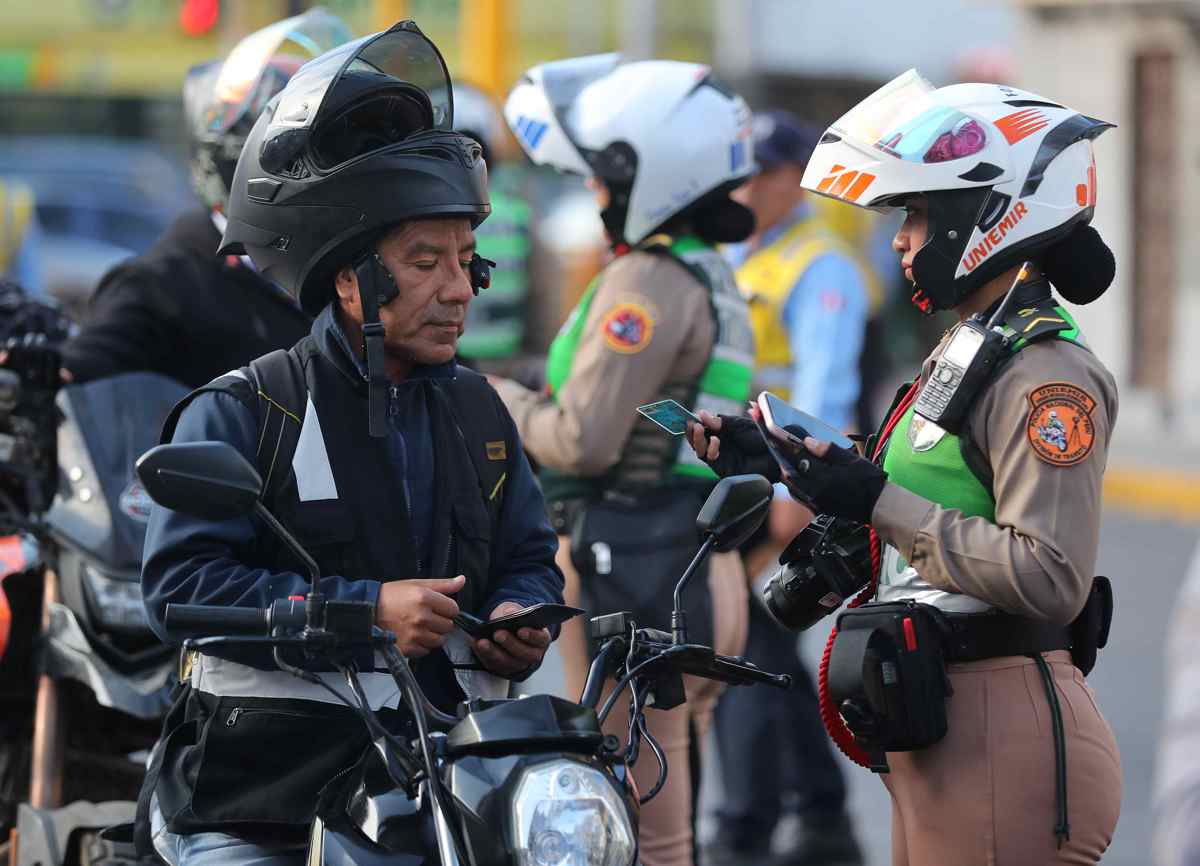 Un integrante de la Policía de Tránsito habla con un motociclista este lunes, en Lima (Perú). (Foto de Paolo Aguilar de la agencia EFE)