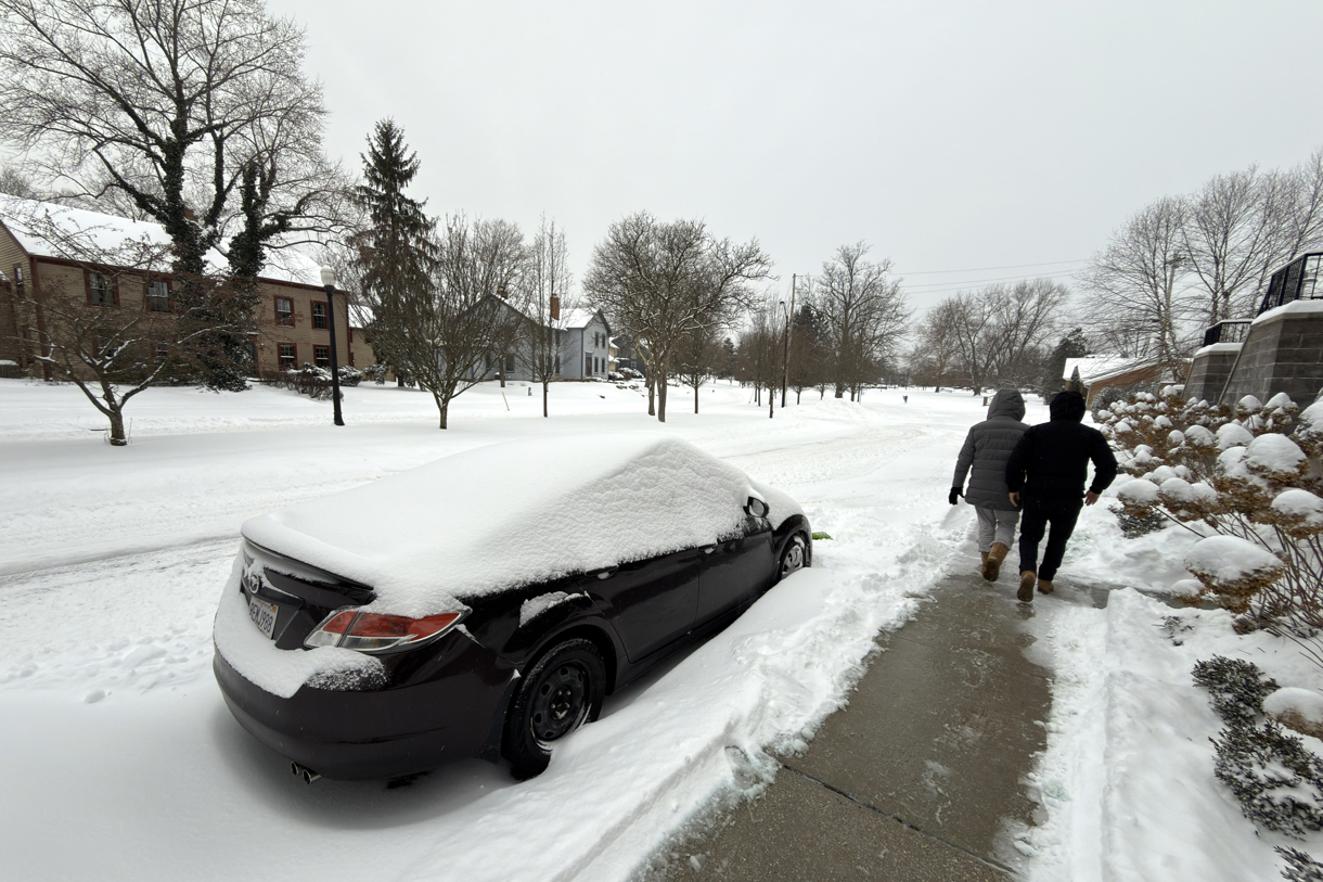 Dos personas caminan al lado de una calle afectada por la nieve este domingo en la ciudad de Hudson, Ohio (EUA). (Foto de Rodrigo Sepúlveda de la agencia EFE)