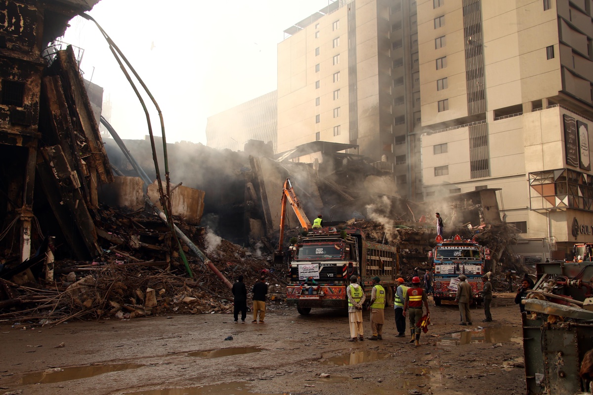 Rescatistas buscan entre los escombros del incendiado Gul Plaza. (Foto de Rehan Khan de la agencia EFE/EPA)
