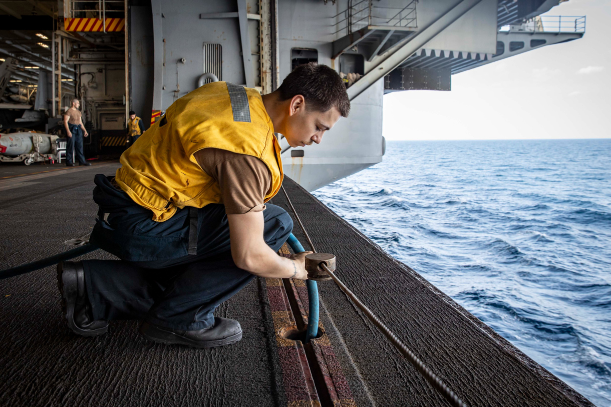 Fotografía tomada de la cuenta en X @CENTCOM del Comando Central de Estados Unidos que muestra a un marinero a bordo del USS Abraham Lincoln (CVN 72) trabajando en el portaaviones este lunes, en el Océano Índico. (Foto de @centcom/EFE)
