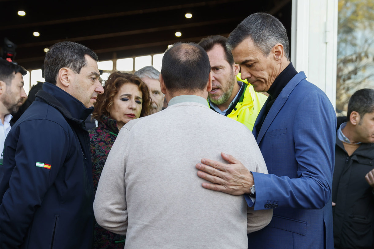El presidente del Gobierno Pedro Sánchez (d) conversa con el alcalde de Adamuz, Rafael Ángel Moreno Reyes (c, de espaldas), y el presidente de la junta de Andalucía, Juanma Moreno (i), en Adamuz, Córdoba, este lunes. Sánchez ha asegurado este lunes desde el lugar donde se ha producido la tragedia ferroviaria de Adamuz, en Córdoba, que se dará con “la verdad” sobre la causa del accidente y se conocerá “la respuesta” al origen del siniestro que ha causado al menos 39 fallecidos. (Foto de Jorge Zapata de la agencia EFE)