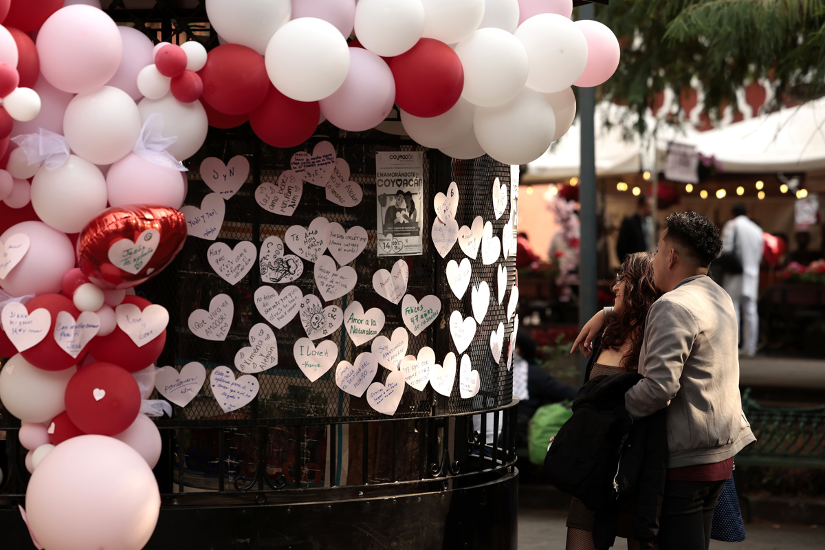 Una pareja lee mensajes escritos durante la celebración del Día de San Valentín, en la Ciudad de México (México). (Foto de José Méndez de la agencia EFE)