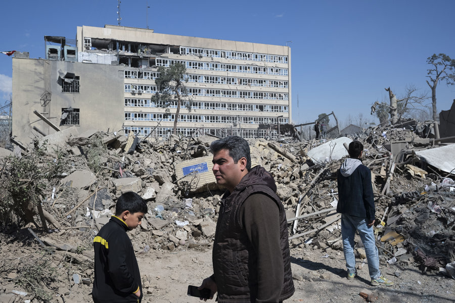Varias personas caminan cerca de una zona alcanzada por los bombardeos israelíes-estadounidenses en los alrededores del Gran bazar de Teherán. (Foto de EFE)