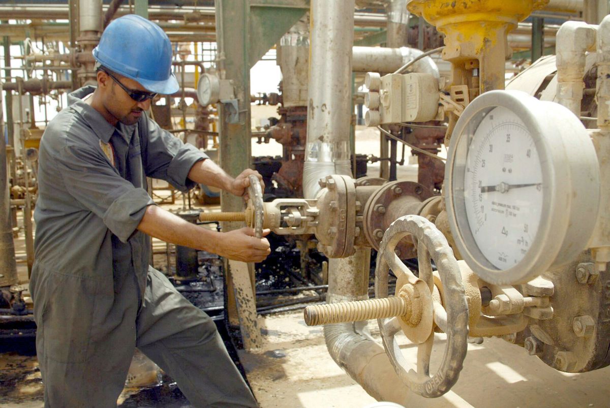 Un operario que abre una válvula en una refinería de Najaf, en Irak. (Fotografía de archivo de Hussein Al-Mousawi de la agencia EFE)