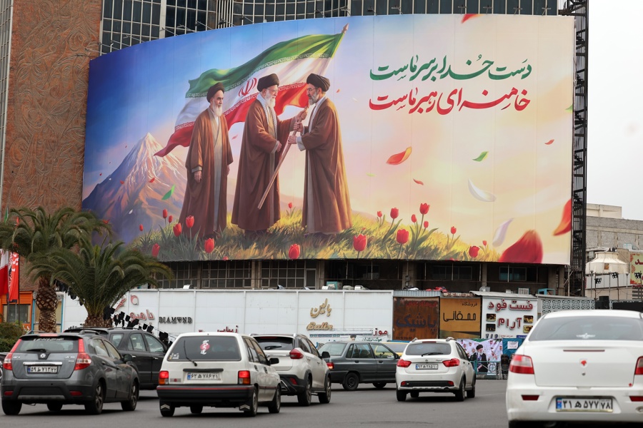 La gente pasa frente a un enorme cartel que muestra al difunto líder supremo iraní Ayatollah Ruhollah Khomeini, Ayatollah Ali Khamenei y al nuevo líder supremo iraní Ayatollah Mojtaba Khamenei en la Plaza Valiasr en Teherán. (Foto de EFE)