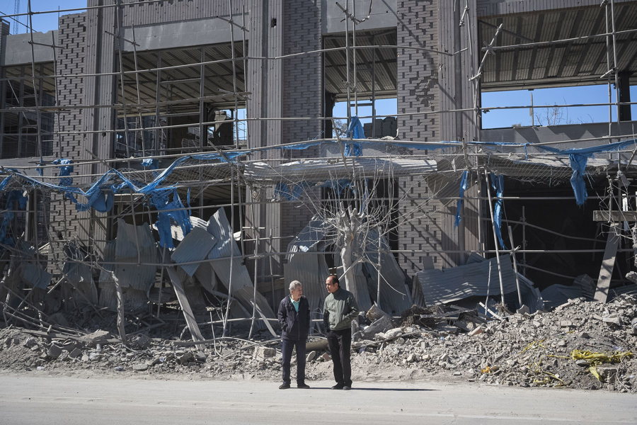 Dos personas caminan cerca de una zona alcanzada por los bombardeos israelíes-estadounidenses en Teherán, Irán. (Foto de EFE)